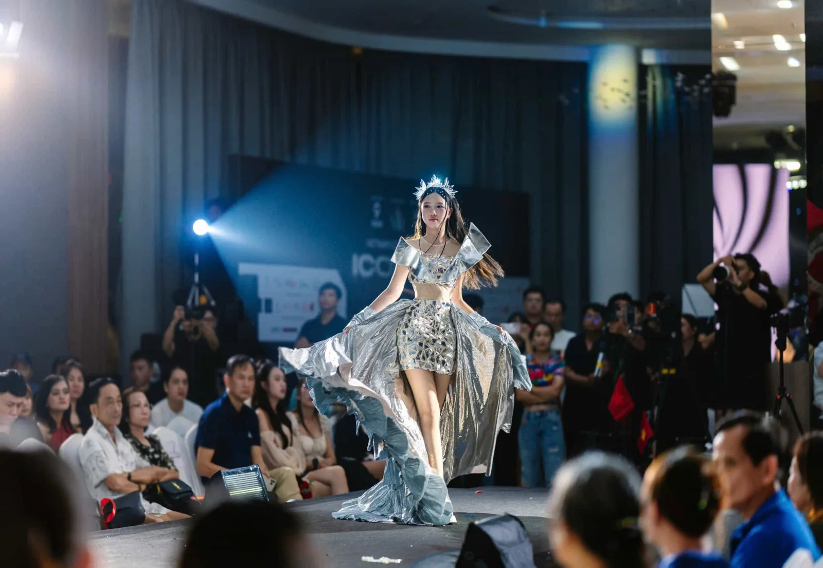 Trần Ngọc Ánh tự tin sải bước trên sàn catwalk, diện bộ váy ánh kim lộng lẫy trước ánh đèn sân khấu và khán giả.
